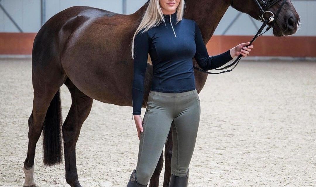 Blonde vrouw in een paardrijbroek